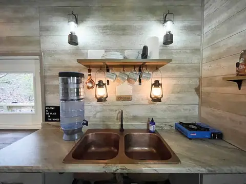Copper kitchen sink under lantern lights, with the pour-over coffee station